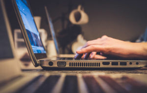 homme tapant sur le clavier d'un ordinateur